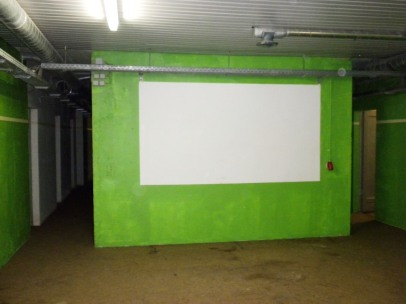 Grüne Wand mit weißer Projektionsfläche in der ehemaligen Abschnittsbefehlsstelle.