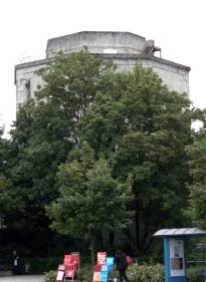Von der Moosacher Straße aus ist der Bunker im Sommer kaum zu sehen, da er vom Grün der Bäume verdeckt wird.